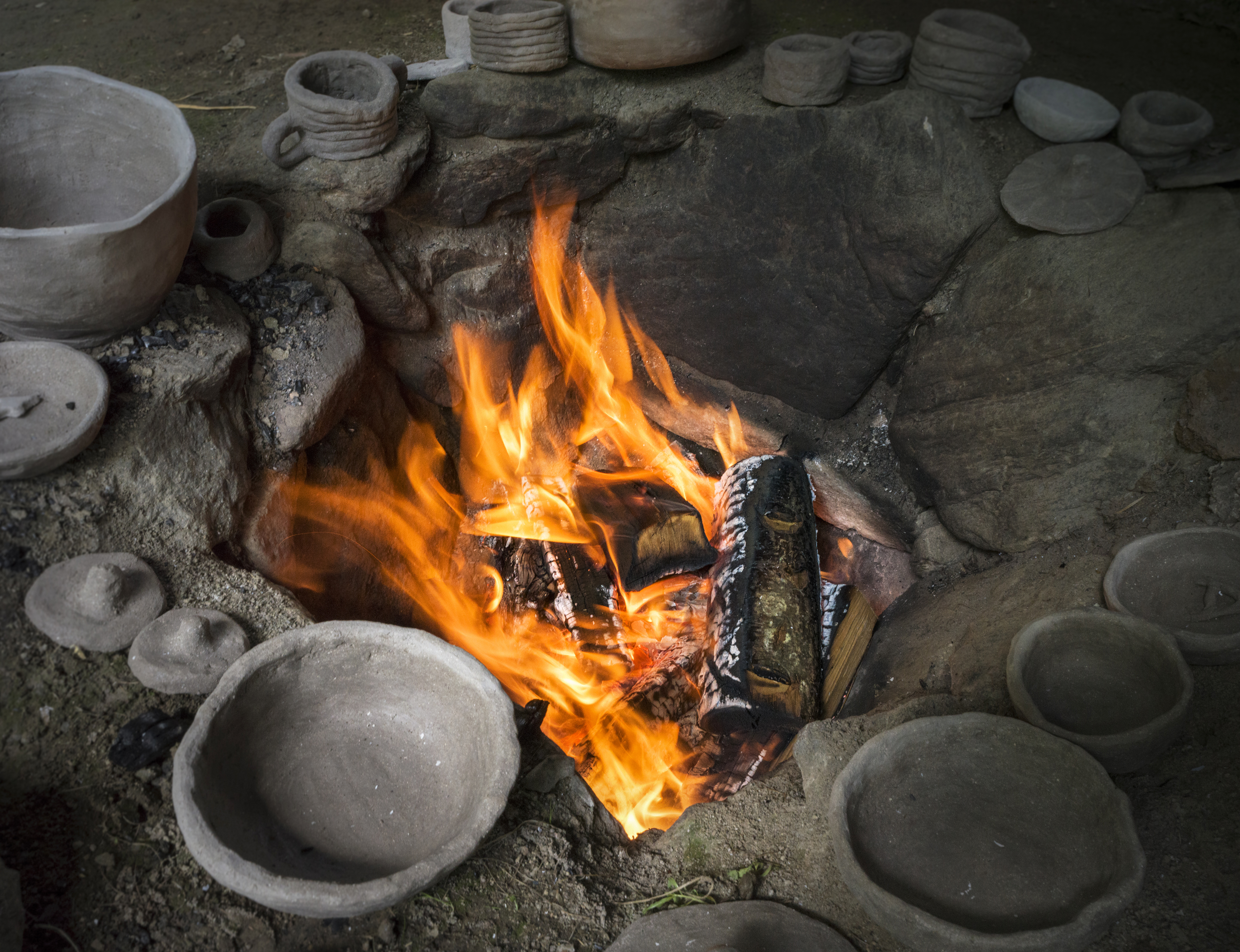 Töpferware bei der Brandgrube im Freilichtbereich des archeoParc Schnalstal in Südtirol  Oggetti in ceramica accanto al pozzo del fuoco nellarea allaperto nellarcheoParc Val Senales in Alto Adige  Ceramic objects by the fire pit at the open-air area of archeoParc Val Senales in northern Italy
