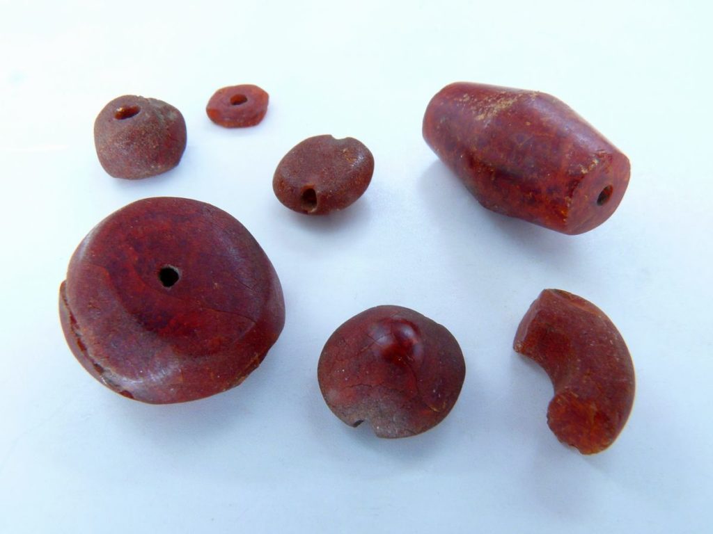 Knpofförmige und doppelkonische Perlen aus baltischem Bernstein<br/>Perline in forme varie in ambra baltica<br/>Differnt types of beads in Baltic amber<br/><br/>1300-1100 BC<br/>Schnals-Finailgrube