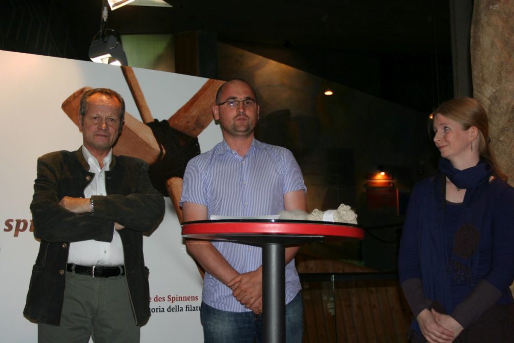 Der Schnalser Bürgermeister Karl Josef Rainer, der Präsident unseres Trägervereins, Alexander Rainer, und die Archäologin und Ausstellungsgestalterin Ulrike Claßen-Büttner (D) bei der Eröffnung der Ausstellung zur Kulturgeschichte des Spinnens im archeoParc<br/>Inaugurazione della mostra Filo fuso<br/>Opening ceremony of the exhibition on spinning by Ulrike Claßen-Büttner (D)