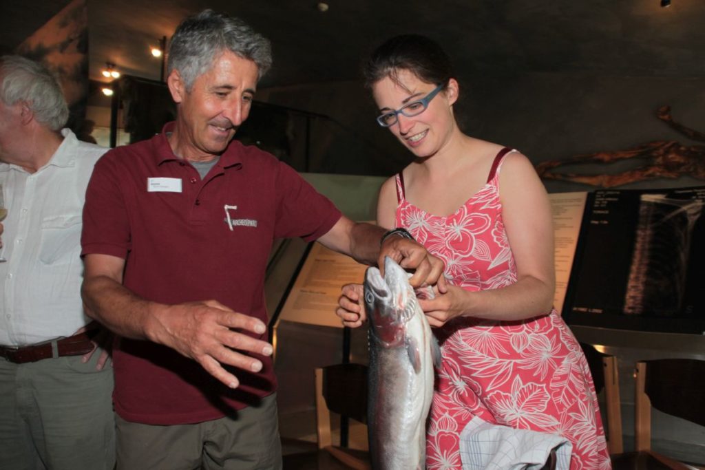 Ernst Gamper und Johanna Niederkofler freuen sich über ein besonderes Geschenk von Fischer Stefan Spechtenhauser anlässlich der Eröffnung der Fischereigeschichte-Ausstellung <br/>Inaugurazione della mostra sulla storia della pesca<br/>Opening of the exhibition on the history of fishing