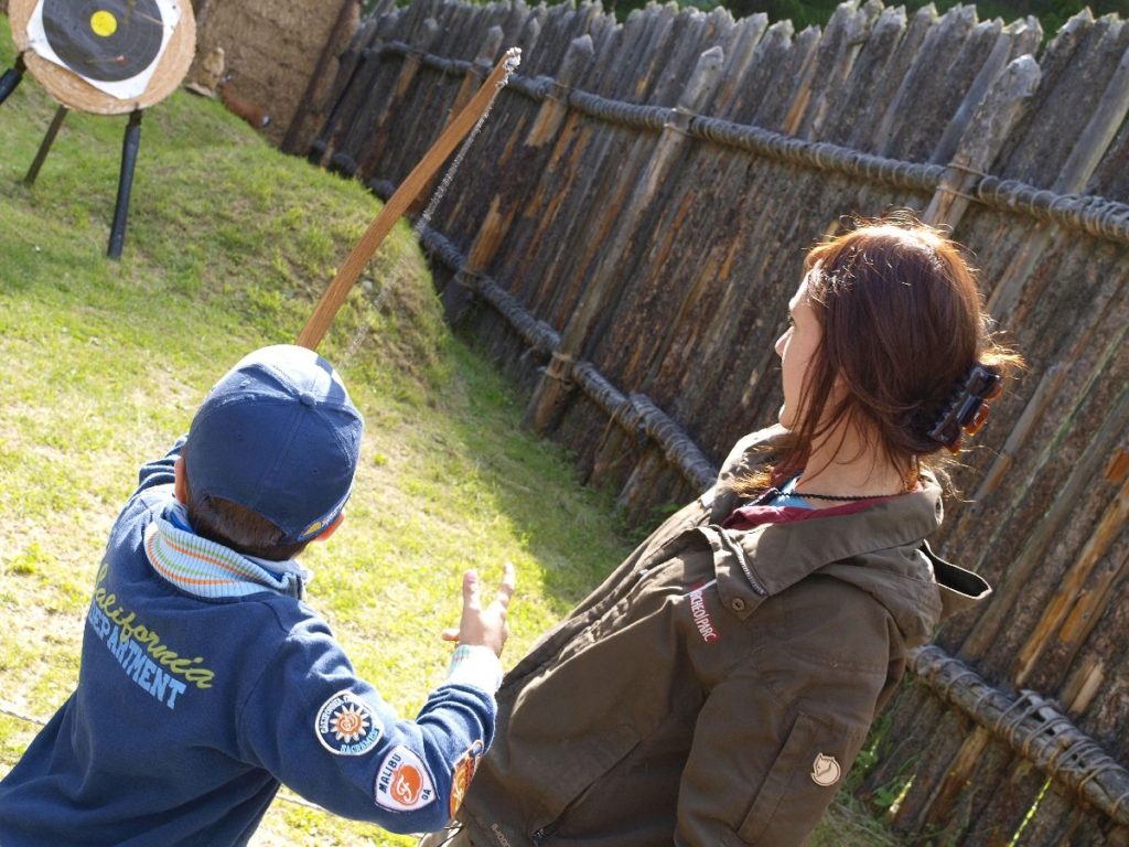 Erste Bogenschießversuche in der Besucherwerkstatt im archeoParc Schnalstal <br/> Laboratorio didattico di tiro con larco preistorico nellarcheoParc della val Senales <br/> Children hands-on workshop on prehistoric archery at the archeoParcVal Senales