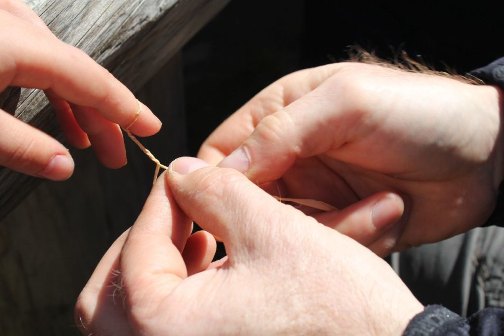 Zwirnen von Bast in der Besucherwerkstatt im archeoParc<br/>Imparare la tecnica del filo ritorto all'archeoParc<br/>Learning the twisting technique at archeoParc Val Senales