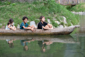 Kinder im Einbaum im Freilichtbereich des archeoParc Schnalstal, Südtirol Bambini nella piroga monossile nellarea allaperto dellarcheoParc Val Senales, Alto Adige Children on a dug out canoe at the open air area of archeoParc Val Senales in northern Italy