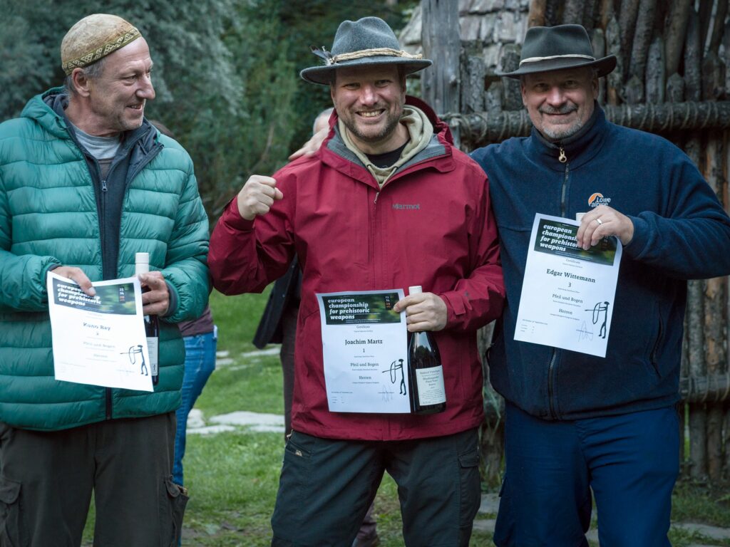 Die Sieger des Bogenbewerbs der Europameisterschaften für Prähistorische Waffen im archeoParc Schnalstal<br/>La premiazione dei vincitori del torneo di tiro con larco allarcheoParc Val Senales, tappa del campionato europeo per armi preistoriche<br/>Presentation ceremony for the winners of the bow competition, og the European Championship for Prehistoric Weapons at archeoParc Val Senales<br/><br/>f.l.t.r.: Kuno Bay (2nd place), Joachim Marz (1st place), Edgar Wittemann (3rd place)<br/><br/>September 2023