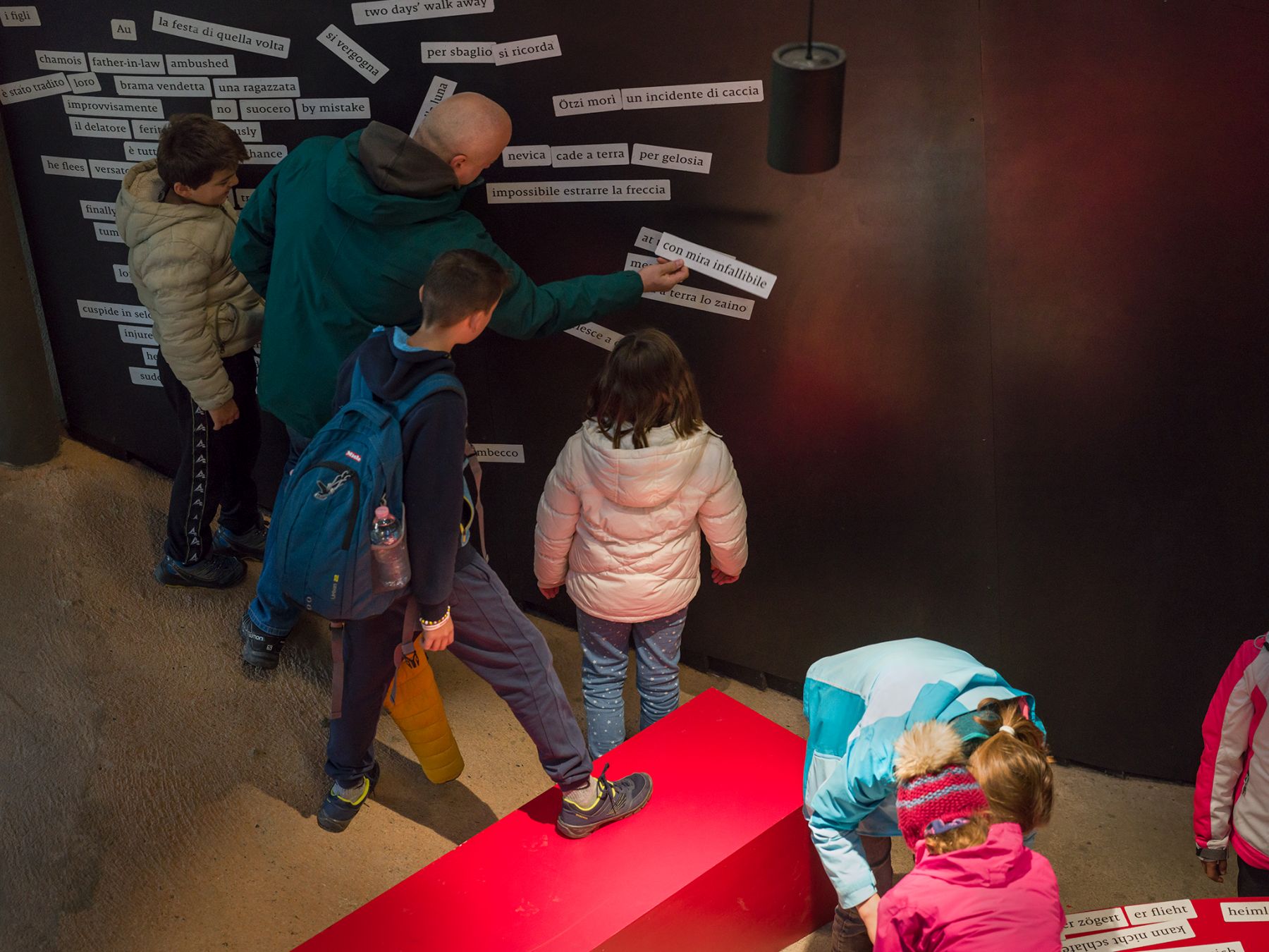 Kinder und Erwachsene vor der interaktiven Magnetwand im Besucherzentrum des archeoParc Schnalstal Bambini e adulti davanti alla lavagna magnetica interattiva nel centro visitatori dell’archeoParc Val Senales Kids and adults in front of the interactive magnetic board at the visitors centre of the archeoParc Schnalstal Val Senales